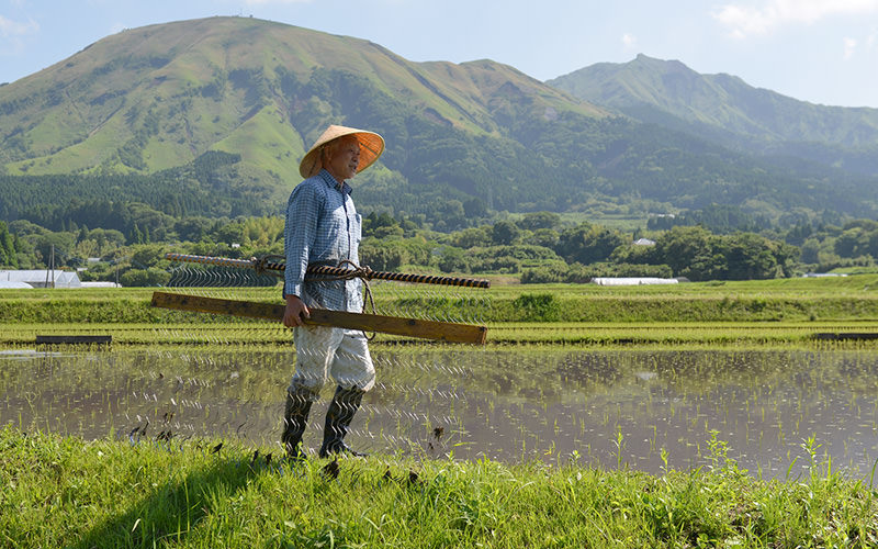 自作した除草機を運ぶ荒牧さん